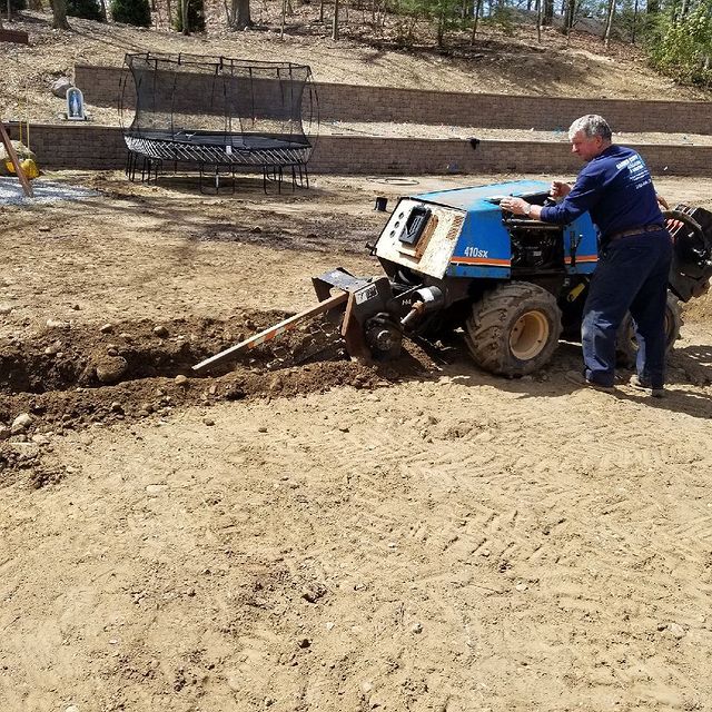 Crew member using equipment to install irrigation lines