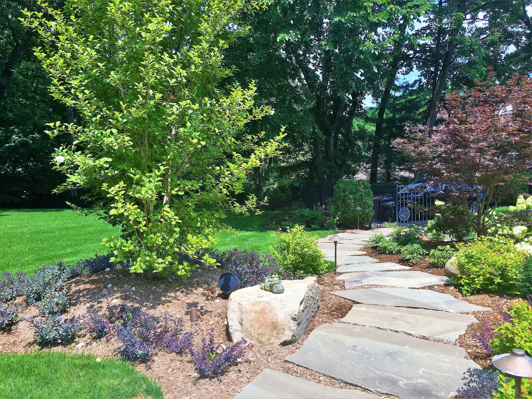 Landscape speaker discreetly installed beside a planted garden walkway